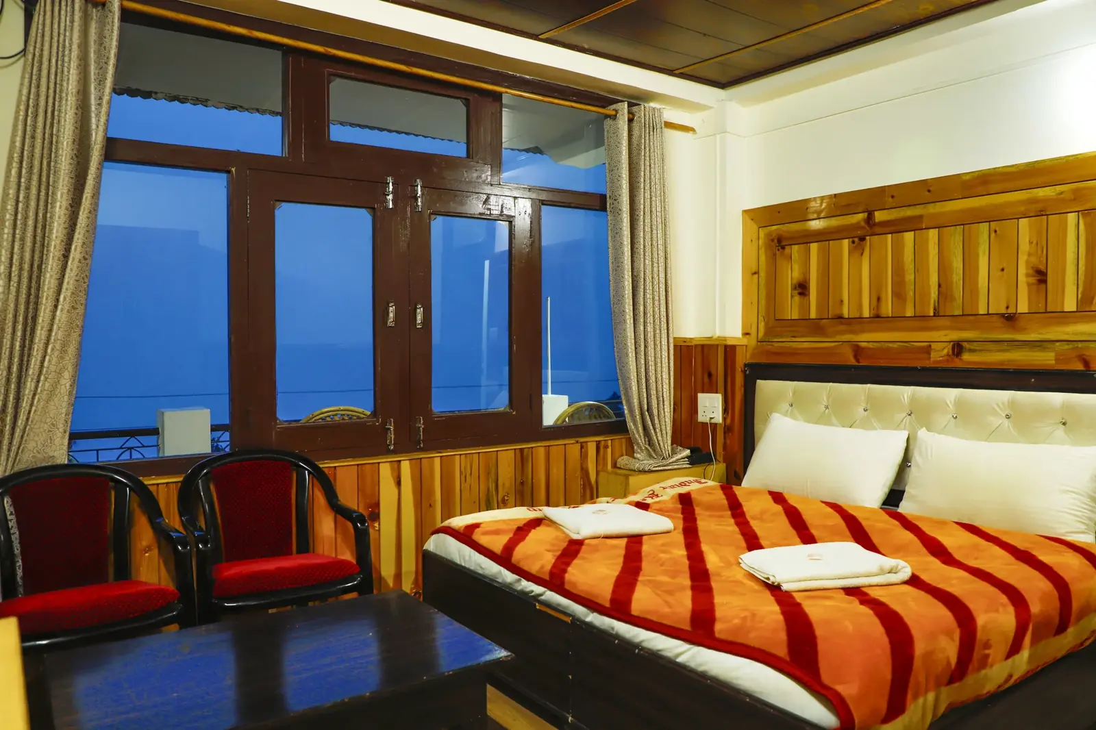 Room with a wall of windows onto the mountains