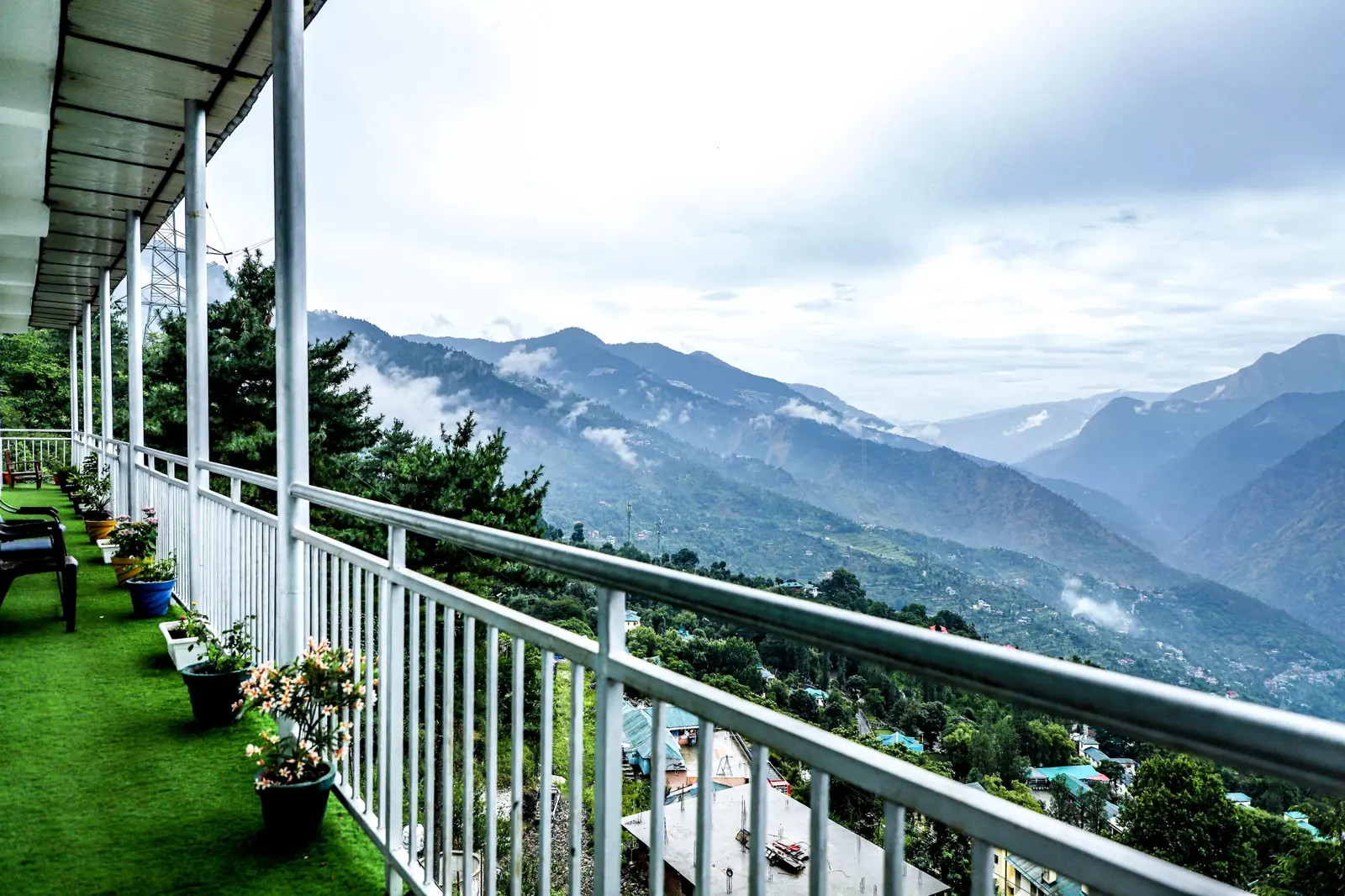 Terrace with flower pots above a deep green valley