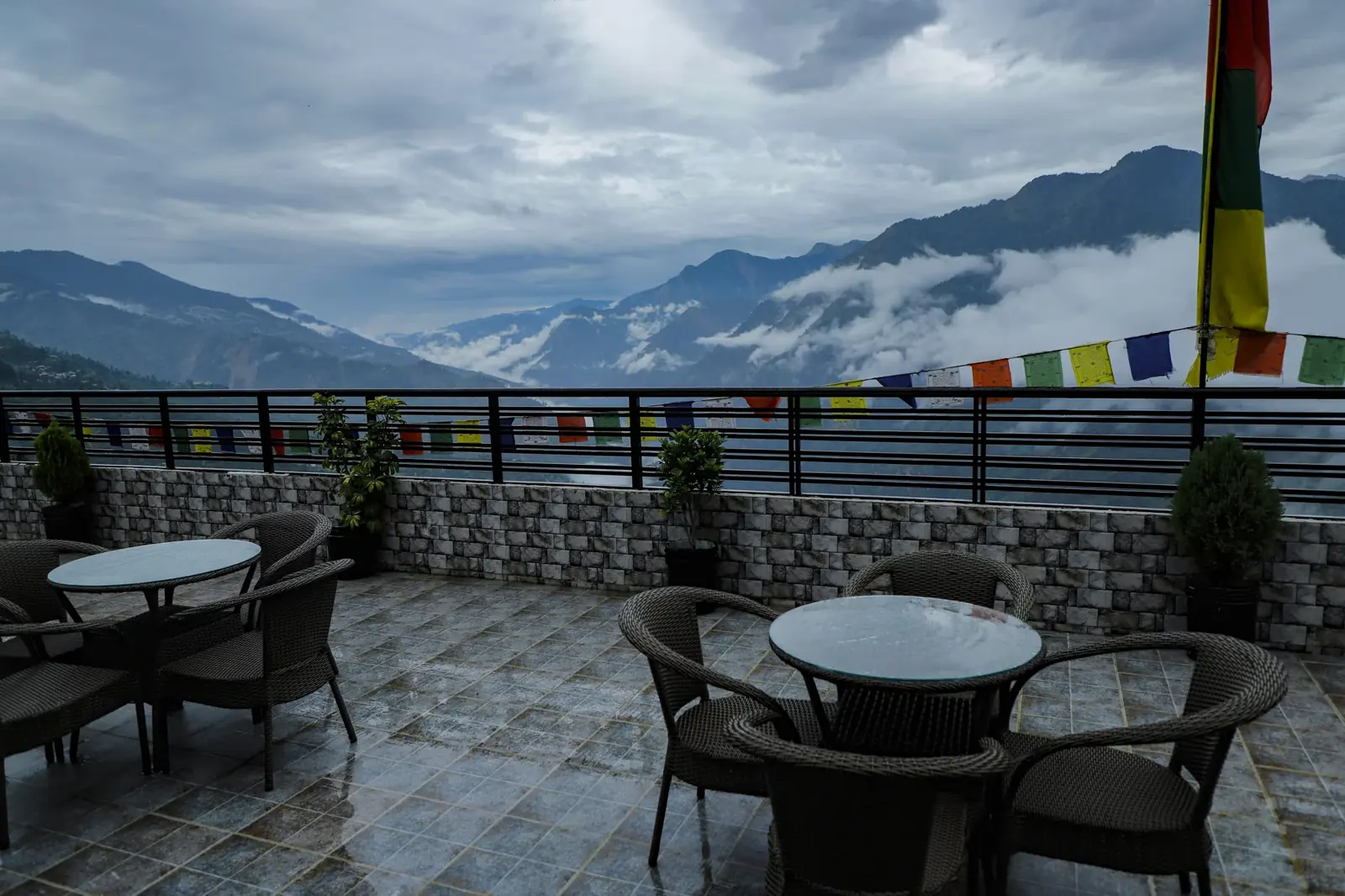 Rooftop terrace with tables, prayer flags and mountain views