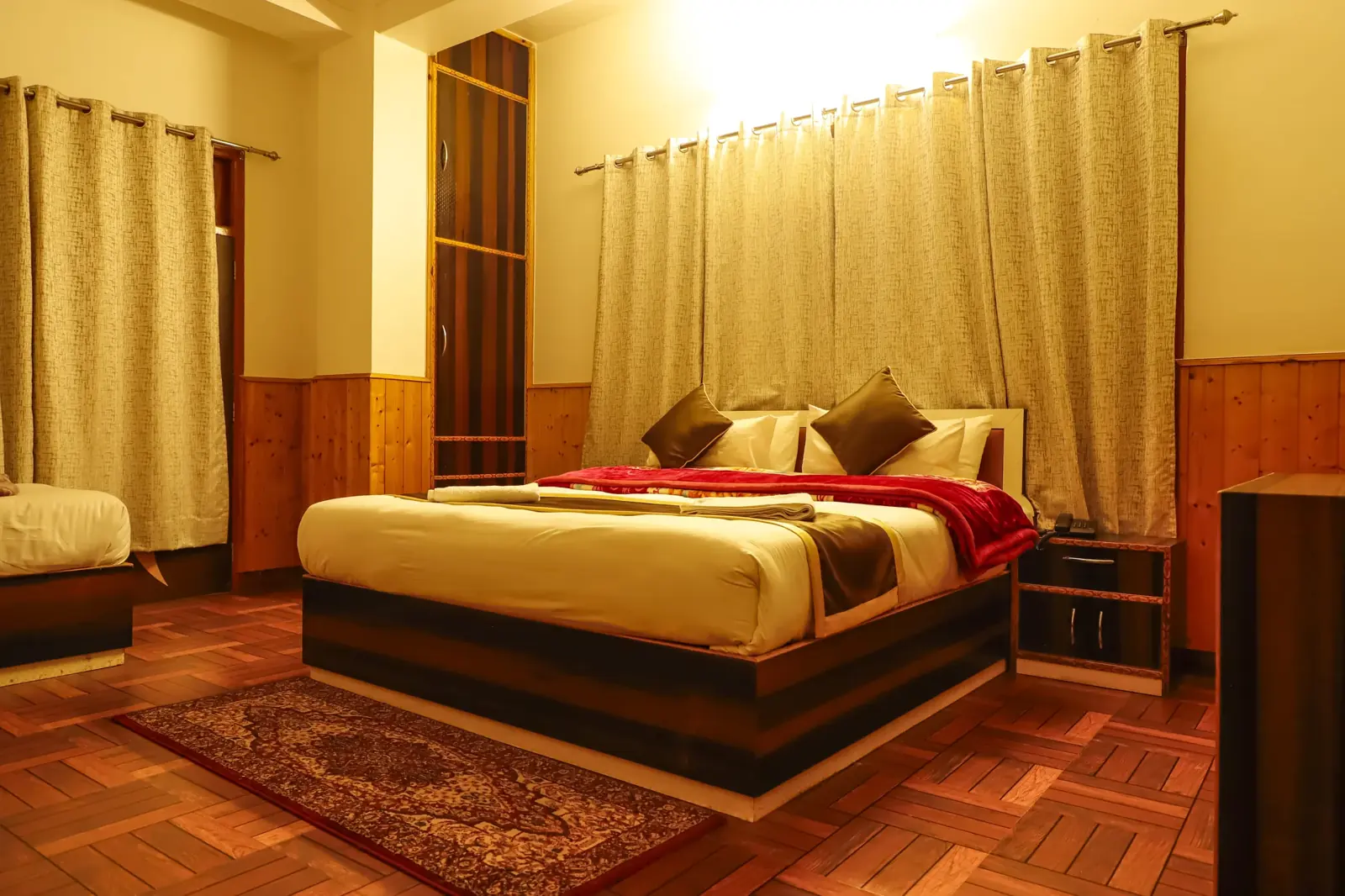 Super Deluxe room with a carved bed and rug