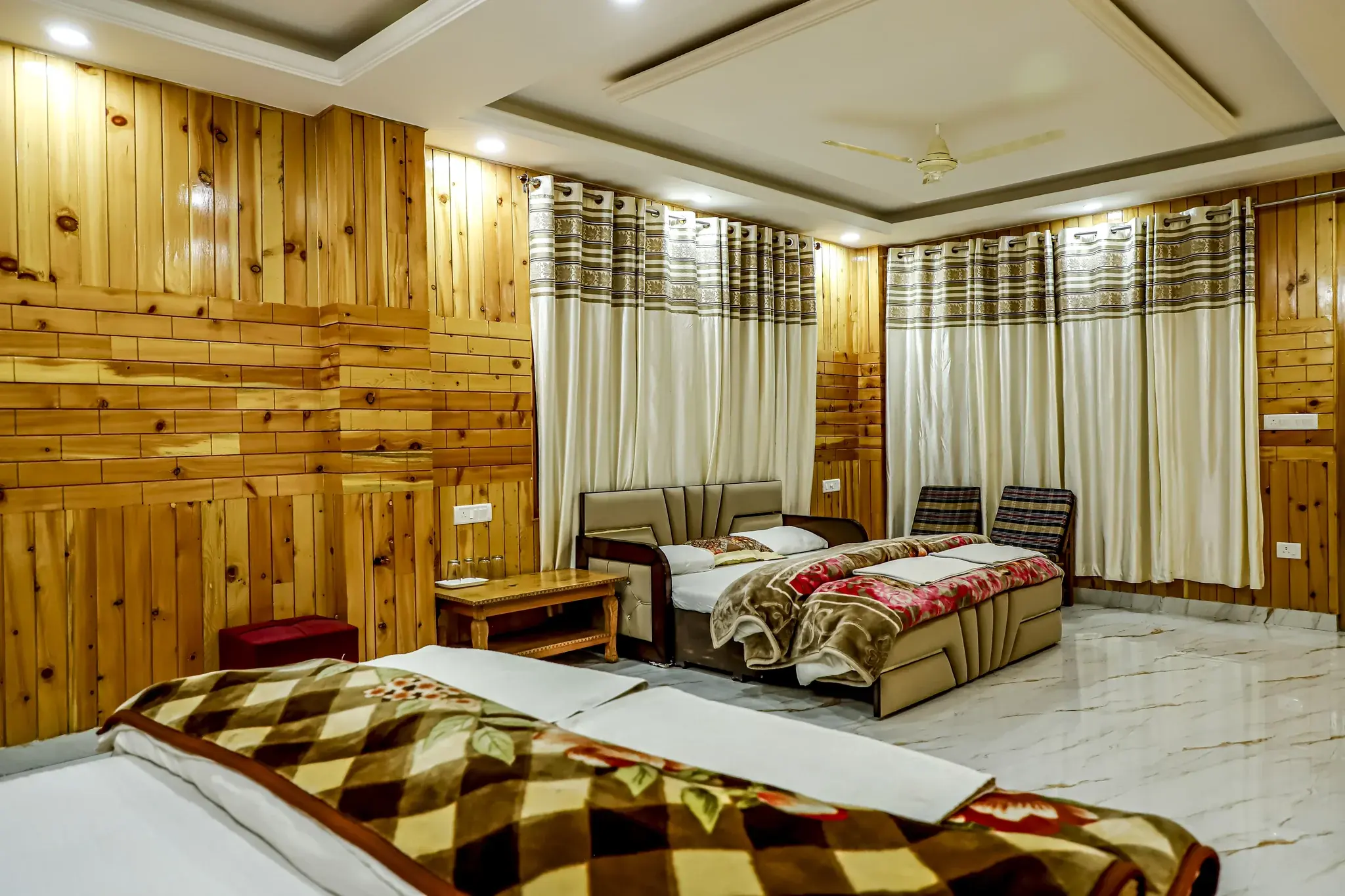 Family room with a sofa and two beds at Hotel White Nest