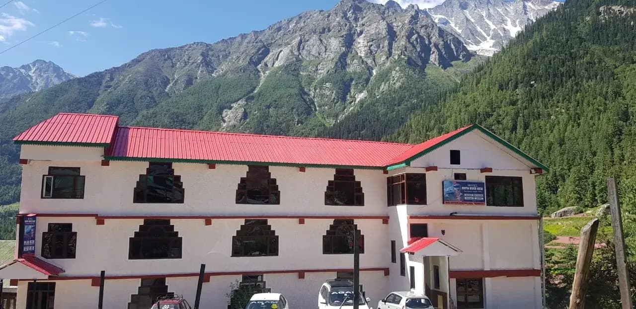 Hotel Legendary Rupin River View, a red-roofed hotel below snow peaks and pine forest in Rakchham