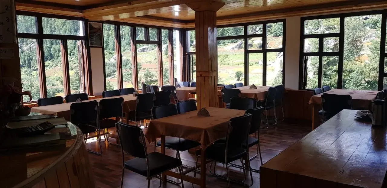 Restaurant with tall windows onto the forest