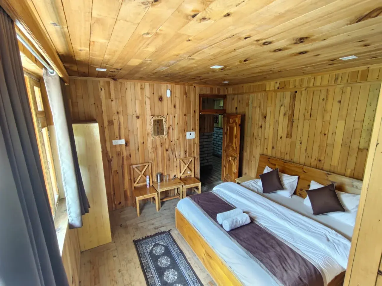 A pine-panelled double room at The Shambhu Lodge